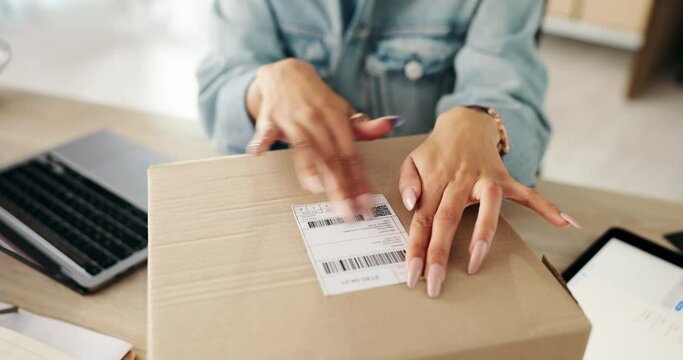 Business woman, hands and label with box in logistics for delivery, supply chain or packaging order on desk. Closeup of female person wrapping parcel, cargo or product for shipment or courier service