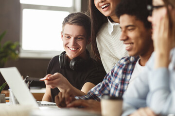 International students looking at laptop in school library, preparing for lectures