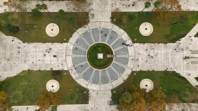 Plaza de Mayo (Buenos Aires, Argentina) with people walking. Top view aerial camera rises from the central circle and shows the whole square