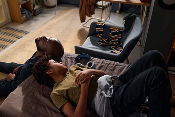 High angle portrait of loving father and son lying on bed supporting each other in mental health trouble copy space