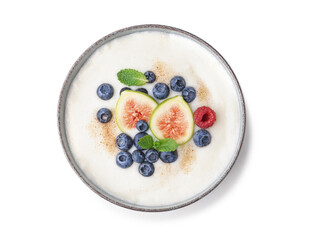 Bowl of tasty semolina porridge with fresh berries and figs on white background