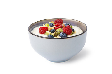Bowl of tasty semolina porridge with fresh berries and kiwi on white background