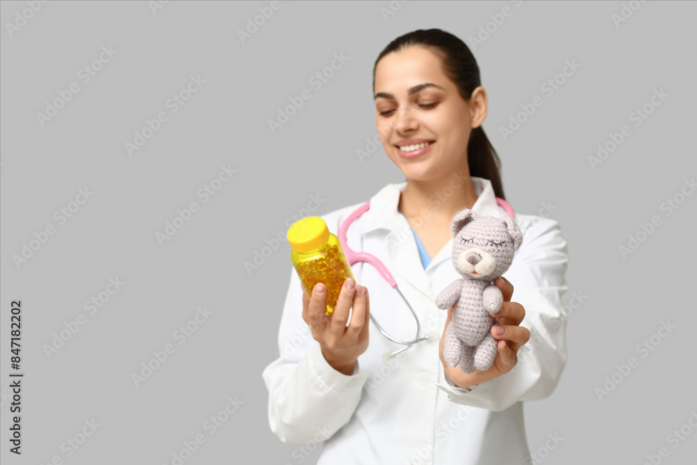 Sticker portrait of female doctor with pills and plush toy on grey background