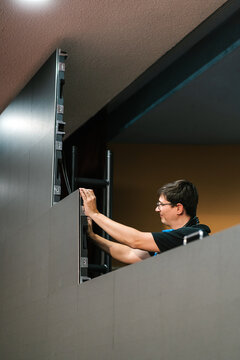 Focused man fixing panel on LED video wall