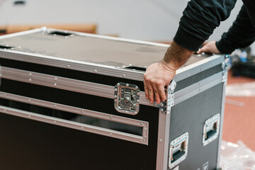 Hands of anonymous person pushing LED panel transport box