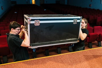 Technicians carrying road case at music concert hall