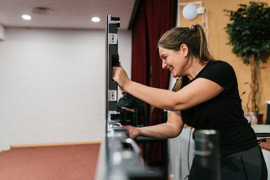 Cheerful woman working on LED video wall