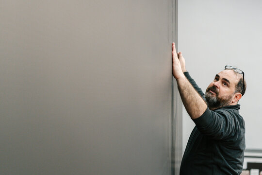 Confident engineer examining screen of video wall after mounting