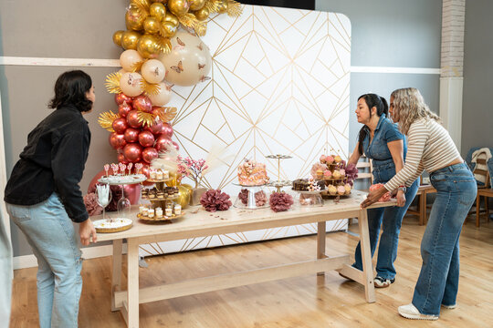 Three women preparing party room.