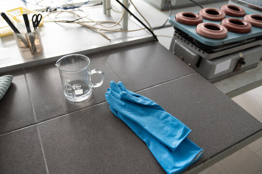 Beaker With Handle And Gloves On Tabletop
