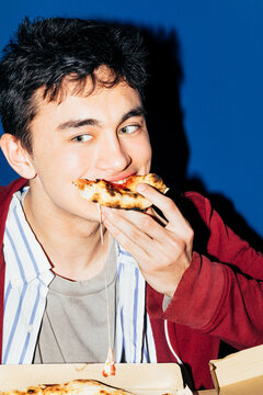 Young man eating pizza 