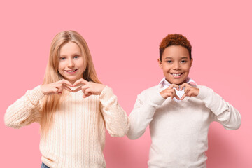 Cute little children showing heart gesture on pink background. Valentine's day celebration