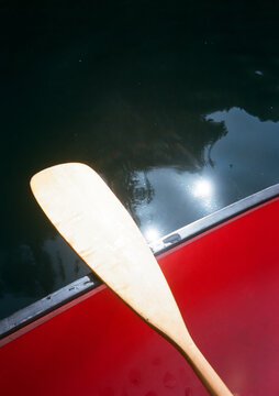 Wooden paddle on canoe above water