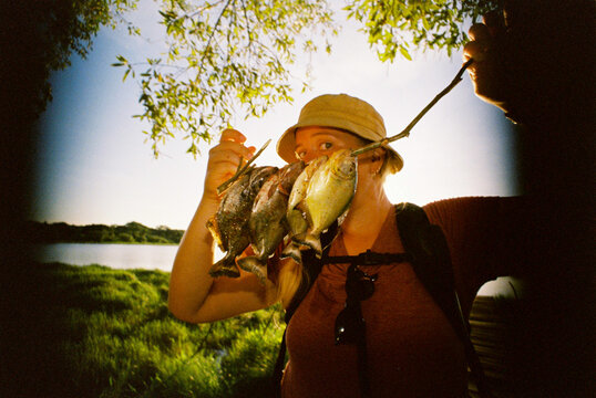 Woman holding freshly fished piranhas 