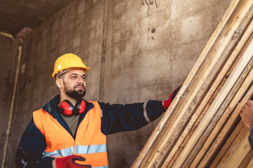 Construction worker carrying a scaffolding at a building site - people at work concepts