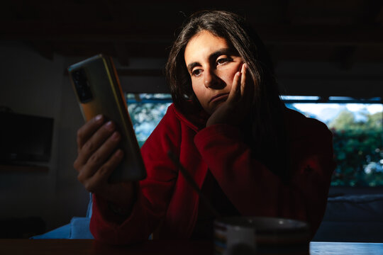 Bored young Adult Woman Scrollin on cell Phone