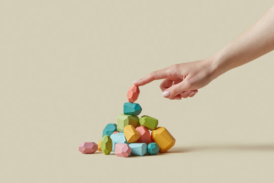Woman's finger touching eco-friendly wooden stone balancing on heap