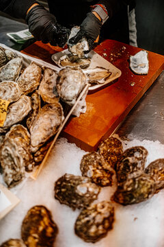Opening an oyster with a knife at the Spanish seafood market