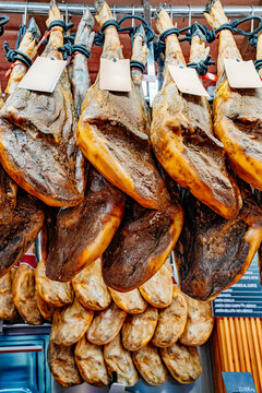 Lots of hamons are hanging in rows at the local Spanish market