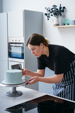 Baker Frosting a Cake in the Kitchen