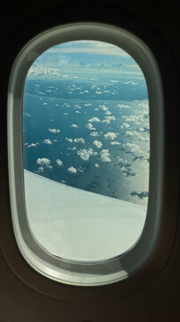 A plane window with a sky and sea view