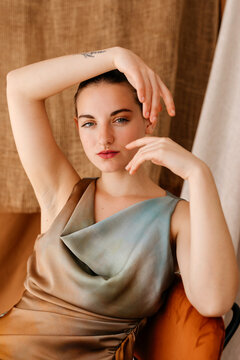 Charming model sitting on chair with hand on head