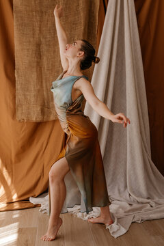 Flexible ballerina practicing ballet with arm raised