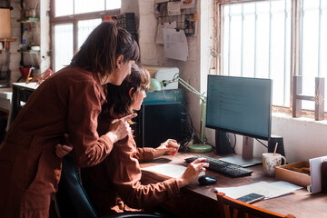 Small business owners checking client orders on pc