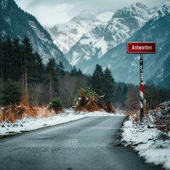 Winter road in the mountains with a warning sign with text "Antworten" and snow on the ground