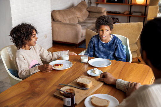 Siblings having breakfast with father at home