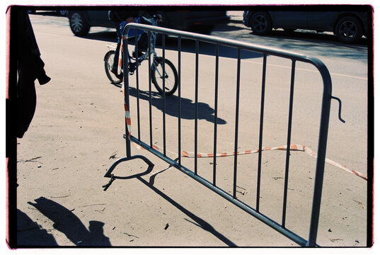 A man on a bicycle and a road fence.