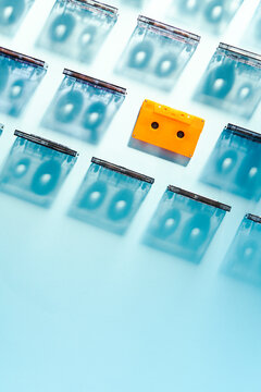 Silhouettes of cassette tapes with one orange cassette