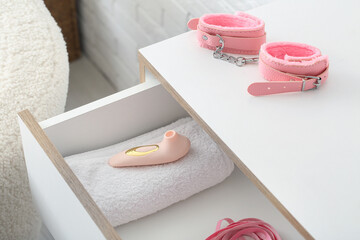 Opened chest of drawers with different sex toys in room