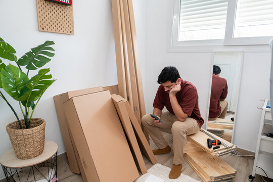 Frustrated man assembling furniture