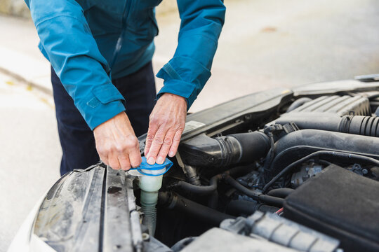 Hands of a senior man closing water coolant tank