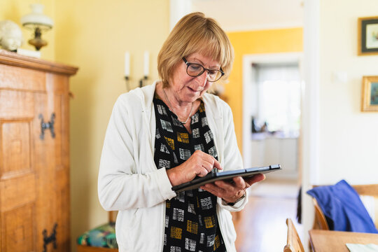 Senior woman at home working on a digital tablet