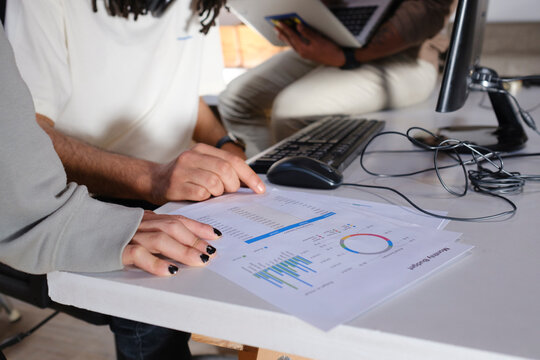 Crop of startup team looking at company results document