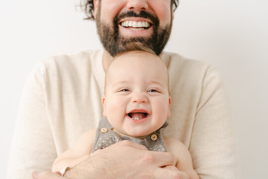 portrait of  happy father  with smiling baby in studio  - Powered by Adobe
