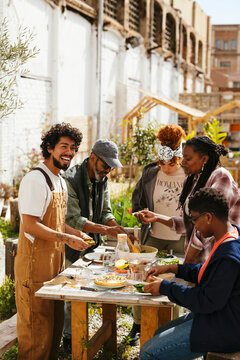 Diverse friends having lunch in community garden