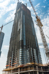 Fototapeta premium Construction site with cranes building modern skyscraper