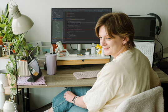 Female programmer pensively looking out from her workplace