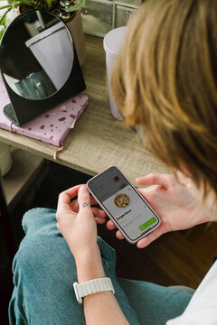 A young woman orders a pizza using her smartphone