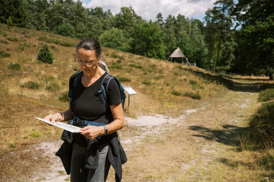 woman hiking and reading map in lower saxony germany