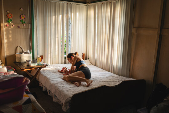 Mother with her newborn baby on the bed.