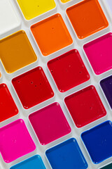 a set of watercolor paints in round bags in a white case
