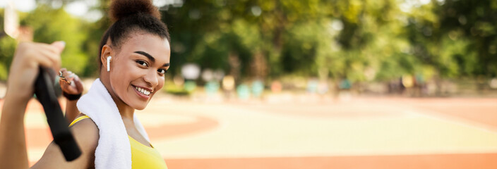 Portrait of smiling African American woman doing workout training using equipment for body...
