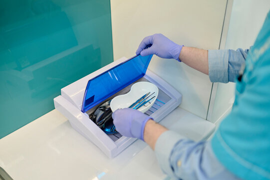 Male hands take out instruments from sterilizer