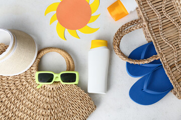 Bottles of sun protection cream and beach accessories on white background
