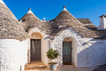 Famous traditional old dry stone trulli houses with conical roofs in Alberobello, Italy.