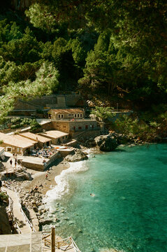 Film photo Secluded Beach Cove with Quaint Village. Majorca, Spain